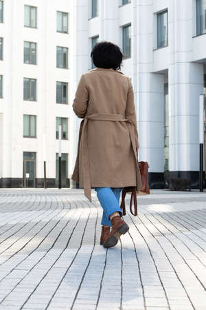 Pretty woman goes to work in a business center in stylish clothes down the street.の写真素材