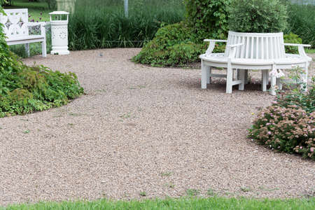 Landscaping of the local area with white benches, gravel paths and flower beds.の写真素材