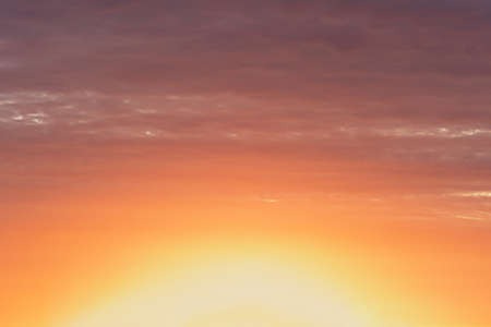 Bright colorful sky at sunset in orange pink and purple colors.の写真素材
