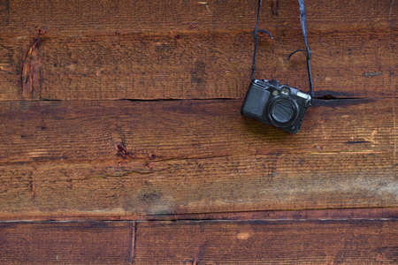 Vintage digital compact photo camera hanging on a wooden wallの写真素材