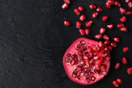 Fresh ripe pomegranate fruit on wet black stone vintage backgroundの写真素材