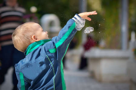 Boy splashing soap bubbles in parkの写真素材