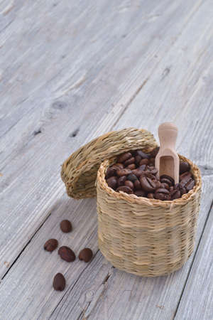 Vintage cup with coffee beans on a vintage white wood tableの写真素材