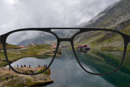 Clear image in glasses against blurry landscapeの写真素材