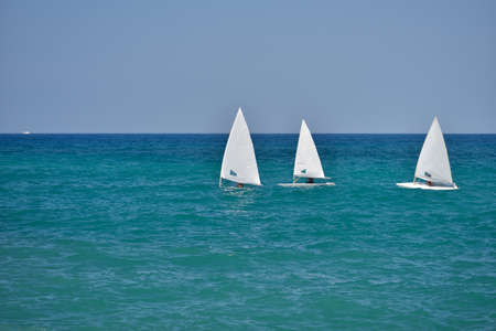 Small sailboats sailing in the calm waters of the Adriatic Sea, south Italyの写真素材