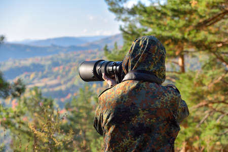 Wildlife, nature man photographer in camouflage outfit shooting, taking picturesの写真素材