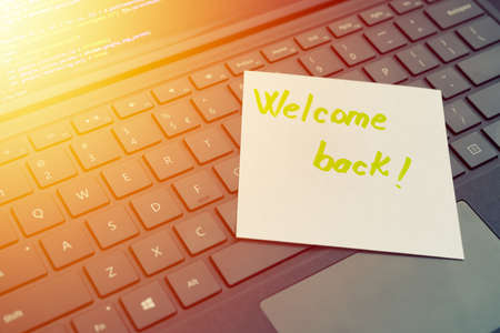 Welcome back message concept written post it on laptop keyboardの写真素材