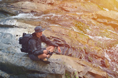Nature professional photographer resting near a waterfallの写真素材