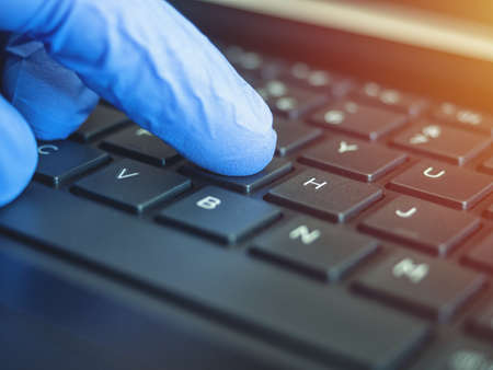 Online quarantine training. Remote online work. Coronovirus. Epidemic. Hands in protective medical gloves are typing on the keyboard.の写真素材