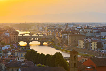 Florence, Italy - July 19, 2017: View of the River Arno and famous bridge Ponte Vecchio. Amazing evening golden hour light. Beautiful gold sunset in Florence, Italyのeditorial素材