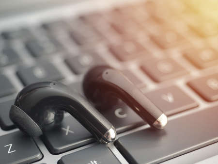 wireless headphones on a laptop keyboard. Watching movies and listening to music on a laptop using...