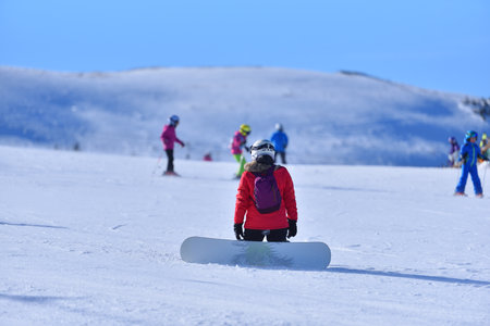 A Moment of Reflection - Snowboarder Takes a Break to Enjoy the Splendor of the Snowy Terrainの写真素材