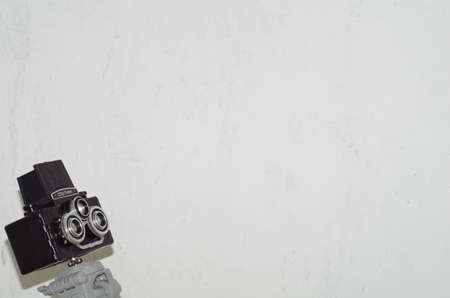 Old film stereo photo camera on tripod near white wallの写真素材