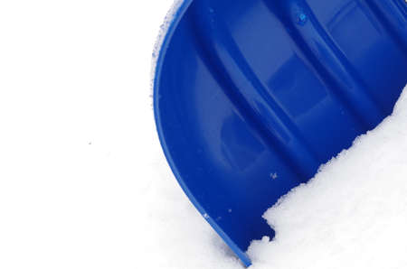 The blue plastic snow shovel stuck in the snowの写真素材