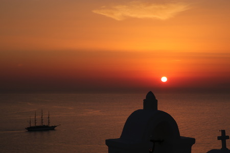 Santorini sunset with sailing boat and church towerのeditorial素材