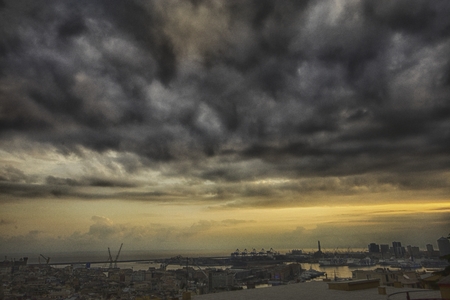 storm clouds over a port city at duskの写真素材