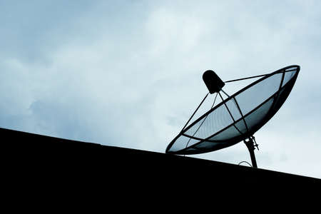 Satellite dish antenna in rural area, silhouette backgroundの写真素材