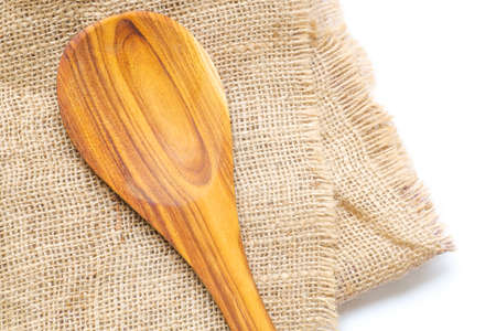 Empty wooden spoon on burlap background for food products, food ingredients display. Clean food, organic food, natural food concept. Food background.の写真素材