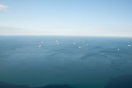 steep rocky coastal lookout point ridge and cliffs overlooking ocean with a city in the distance.の写真素材