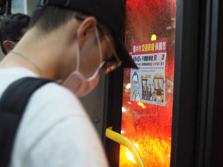 Taichung, Taiwan - 17 April 2020: A man wear mask stand next to bus door with epidemic prevention...