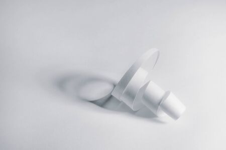 A spiral of cut white paper on a bright white background.   A composition focusing on shape, simplicity, and shadow.の写真素材