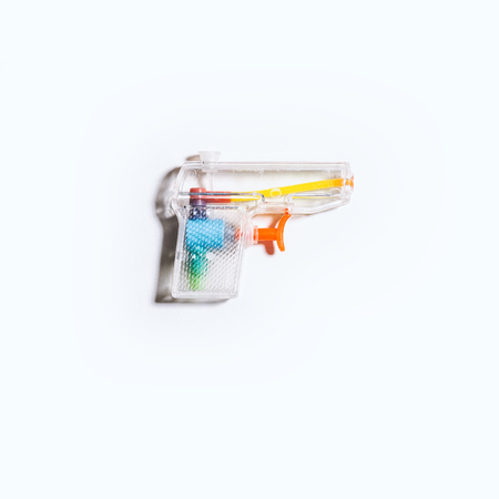 A clear plastic toy squirt gun/water pistol on a bright white background.の写真素材