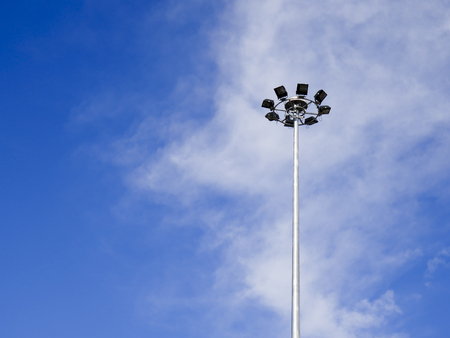 The light on the steel pole with blue sky and white cloud background.