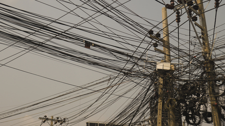 Communication lines that look cluttered on electrical poles, Look disorganized.の写真素材