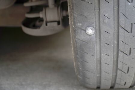 Close-up of the tire where the screw is stuck, causing the tire to leak, The most problems that cause flat tires.の写真素材