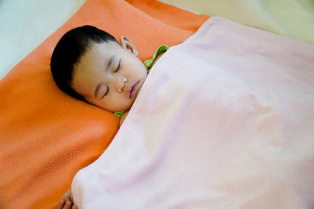 Close-up of a baby sleeping in bed.の写真素材