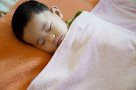 Close-up of a baby sleeping in bed.の写真素材