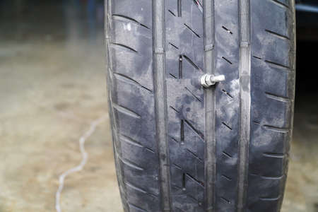 Close-up of the tire where the screw is stuck, causing the tire to leak, The most problems that cause flat tires.の写真素材