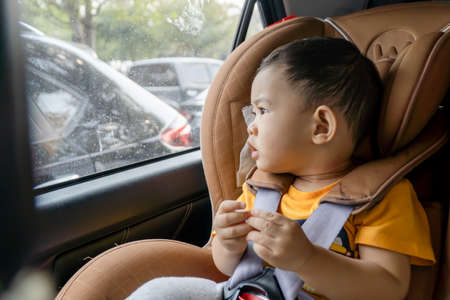 Close-up of little boy children on a car seat in the car.の写真素材