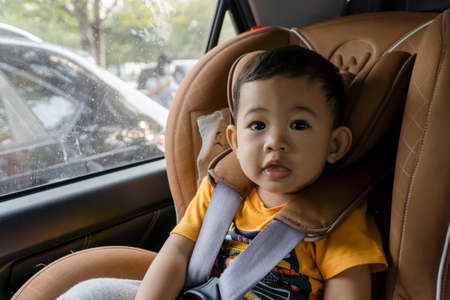 Close-up of little boy children on a car seat in the car.の写真素材