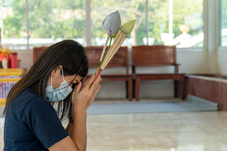 Young Asian women are making a wish in a temple, Concepts of life, hope, belief and good luck.