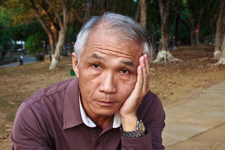 A Frustrated Chinese middle-aged man Aloneの写真素材
