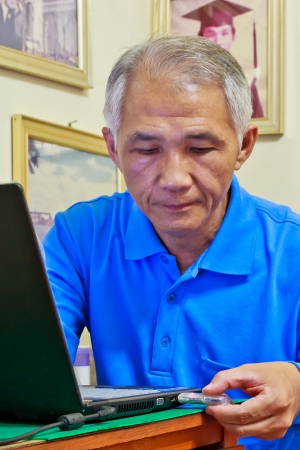 A Middle-aged man who playing computer の写真素材