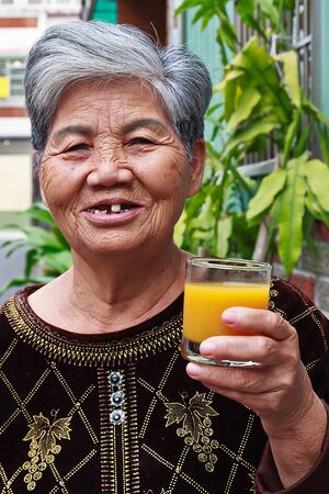 A Chinese Old woman who drinking Orange juiceの写真素材