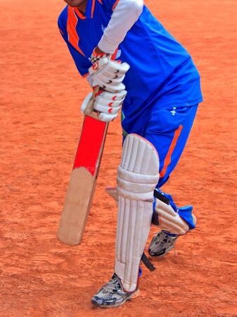 A Uniform Cricketer with kneepads and Gloves who training in Courtの写真素材