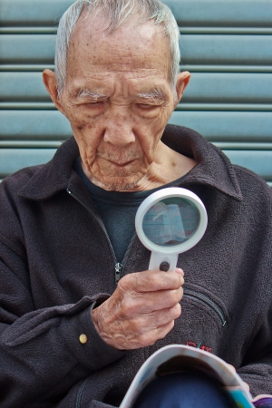 The Old people who Holding a magnifying glass for readingの写真素材