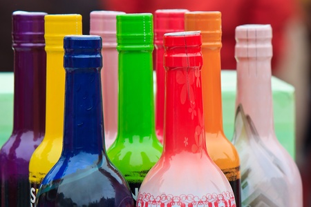 Arrangement of colored wine bottles on saleの写真素材