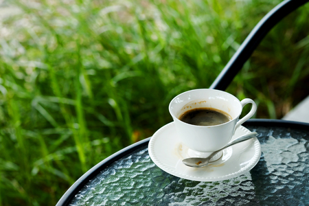 relaxing with hot black americano coffee Serve in white cup in garden in the afternoonの写真素材