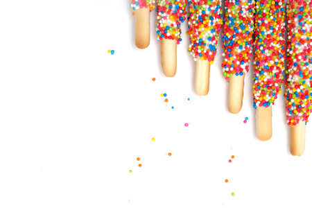 Colorful biscuit stick coated enamel rainbow sugar with white space background for writing wordingの写真素材