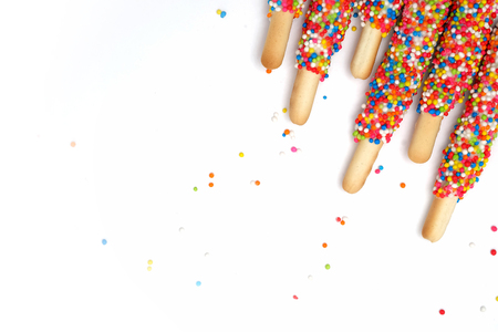 Colorful biscuit stick coated enamel rainbow sugar with white space background for writing wordingの写真素材