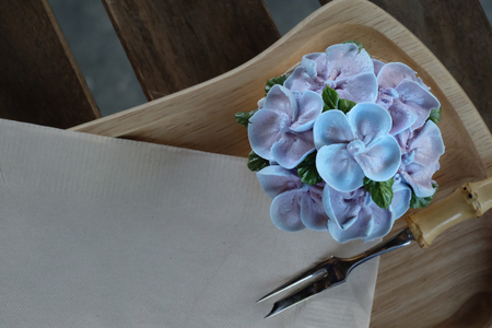 Blue cupcake design cream like blue Hydrangea flower Served on wooden tray with brown paper napkin and little fork,have some space for write wordingの写真素材
