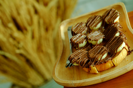 Toast with banana and hazelnut spread on light wooden tray.have some space for write wordingの写真素材