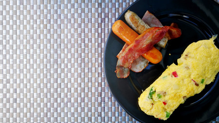Served healthy protein breakfast with sausage and omelet on black plate. Flat-lay view and have some space for write wordingの写真素材
