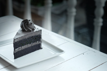 A piece of charcoal cake on white wooden table. Have some space foe write wordingの写真素材