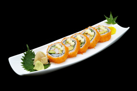 California sushi roll on white plate. Japanese tradition food with black isolated backgroundの写真素材