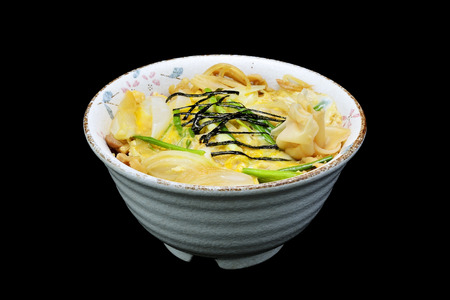 Japanese tradition food. katsu donis  a fried pork with egg and onion in a rice in bowl with black isolated backgroundの写真素材
